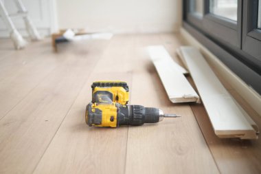 Yerde elektrikli bir tornavida var.