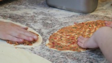  Şefin elleri elleriyle hamurdan yuvarlak bir pizza tabanı oluşturuyor...