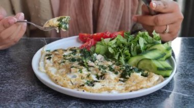 Kadınlar masada yumurtalı omlet yiyor. .