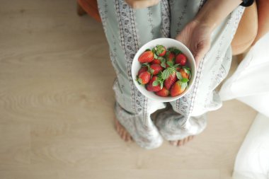 Elle toplanan olgun kırmızı çilekler.