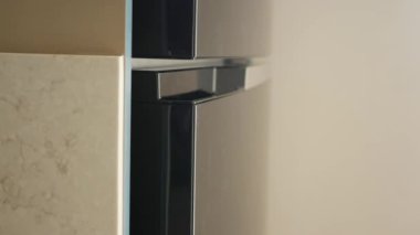 Kadınlar buzdolabının kapısını elleriyle açar. .