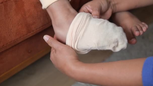 子供の足に靴下を置くこと — ストック動画