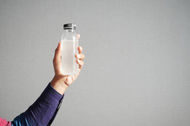 holding dirty bottle of water .