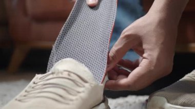 Erkek eli ayakkabıya ortopedik taban koyar. .