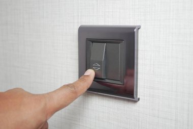 Işık düğmesini açan bir parmak