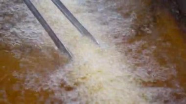 Kızarmış patates kızartması kızartma makinesinde kızgın yağda kızartılıyor.