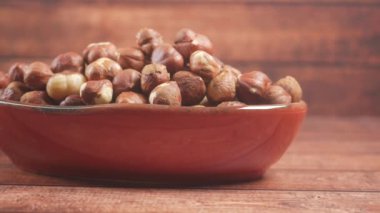 Siyah arkaplanda bir kabın içinde fındıklar