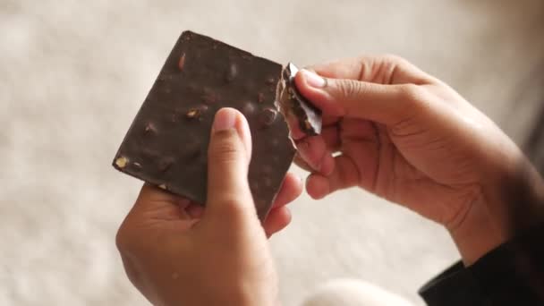 手でダークチョコレートを割る女性のリアビュー — ストック動画