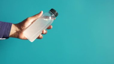 holding dirty bottle of water .