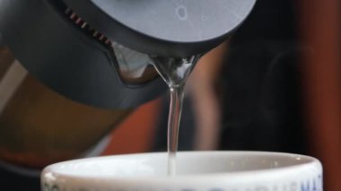 Çaydanlıktan fincana çay doldurur..