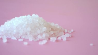 Açık pembe arkaplanda kristal tuza yakın çekim .