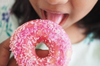  Çocuk ağzı çikolatalı donut yiyor. .