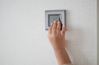  çocuk parmağı kopyalama alanı ile ışıklandırma düğmesini açıyor .