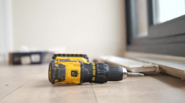 Yerde elektrikli bir tornavida var.