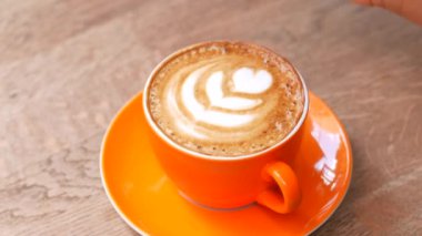 İnsan, kaşıkla kahve karıştırır.