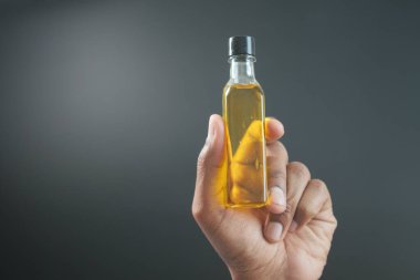 Bir şişe zeytinyağını tutan el. .