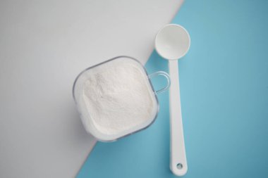 Arka planda bebek sütü tozu ve kaşığı kapat.