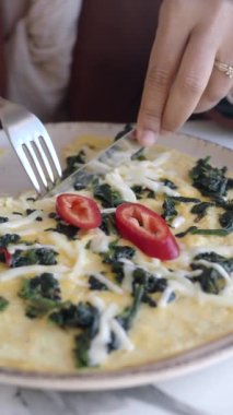 Kadınlar masada yumurtalı omlet yiyor. .