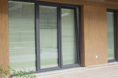  İnce perdeleri ve dışarıdan ev duvarları olan modern bir ön pencere...