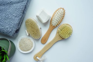 Masada temiz havlu, masaj fırçası ve sabun var.