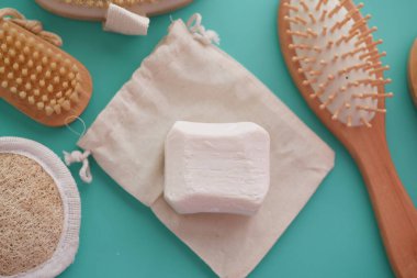 Masada temiz havlu, masaj fırçası ve sabun var.