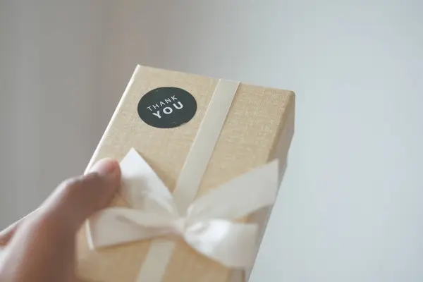 Tangan Memegang Kotak Hadiah Dengan Stiker Terima Kasih Stok Gambar
