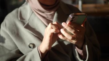  Kadınlar ellerinde akıllı telefonlar, kafede oturuyorlar. 