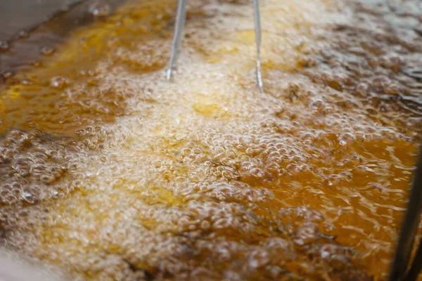 Kızarmış patates kızartması kızartma makinesinde kızgın yağda kızartılıyor.