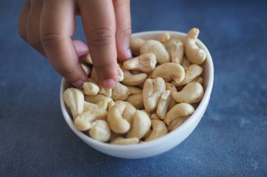 Siyah arka planda küçük bir kasede kaju fıstığı. ,