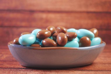  yuvarlak şekilli çikolata mavi ve kahverengi renkli bir kasede .