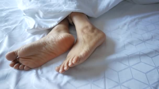 Genç Kadın Çıplak Ayakla Yatakta Yatıyor — Stok video