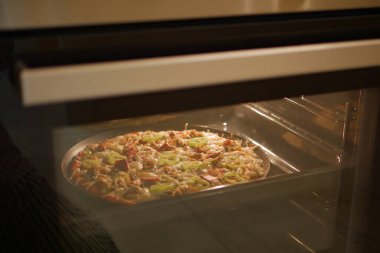 Ev yapımı pizza modern bir elektrikli fırında pişirilir