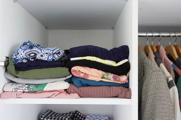 organizing clothes in a closet on shelves for comfort and ease of access