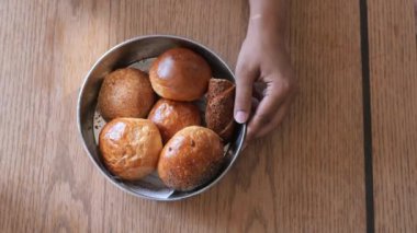 Kadınlar el penayla pişmiş çörekleri masada toplarlar. .
