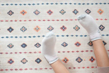 Halıdaki çocuk ayaklarının en üst görünümü .