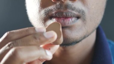 Erkekler ağzına çikolata şekeri koyuyor. ,