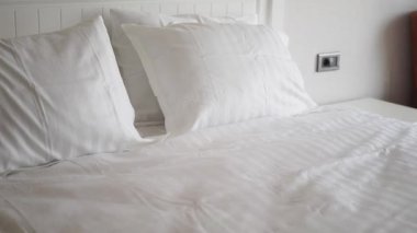 beyaz yastık yatağa dizilmiş. ,