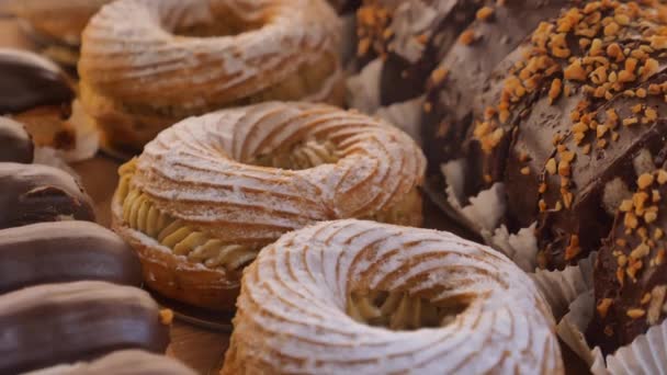 チョコレートドーナツやケーキアイテムが現地のカフェ店で展示されています — ストック動画