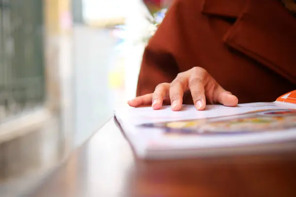 women hand reading a food menu at cafe
