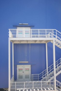 Kentsel tasarım tarzında beyaz merdivenli mavi bina.