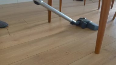 Kadın yer tozunu elektrikli süpürgeyle temizliyor.