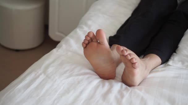 Genç Kadın Çıplak Ayakla Yatakta Yatıyor — Stok video