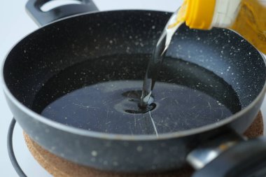 Pişirme tavasına ayçiçeği yağı dökerek .