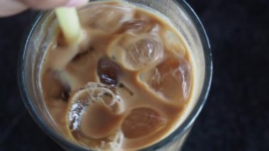 Kafe masasında şeffaf bir bardakta buzlar eridi. ,