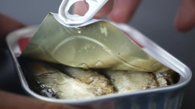 El sardalya konservesini açıyor. ,