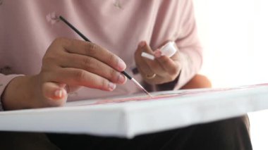 Kadınlar fırçayı boyayla tutarlar. .