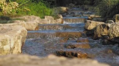 Şelaleyi kapatın. Temiz su taşların arasından akıyor.,