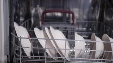 Genç bir kadın, temiz beyaz çatal bıçak çıkartıyor.