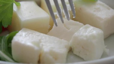 Yemek tabağı dolusu peynir ve marul kareli masa örtüsü..