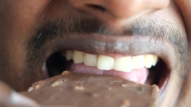 チョコレートキャンディーを食べる男性のクローズアップ — ストック動画